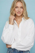 Close-up of a white button-down blouse showing the collar and balloon sleeves.